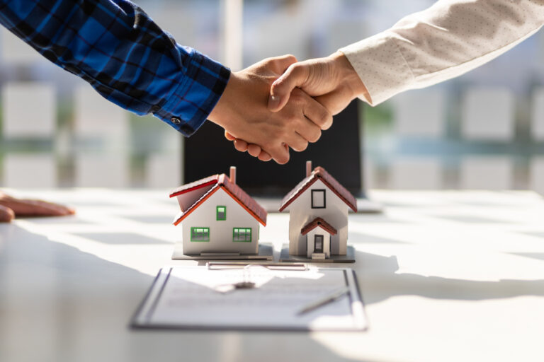 Two parties shaking hands after buying/selling a house